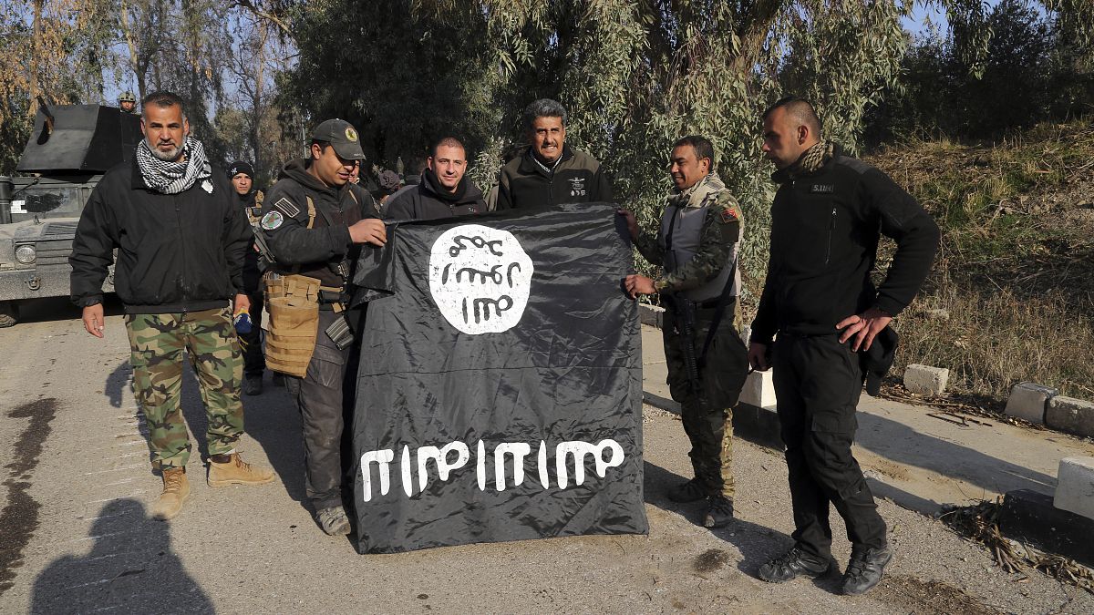 عراقيون يحملون علم داعش بعد استعادة السيطرة على الموصل
