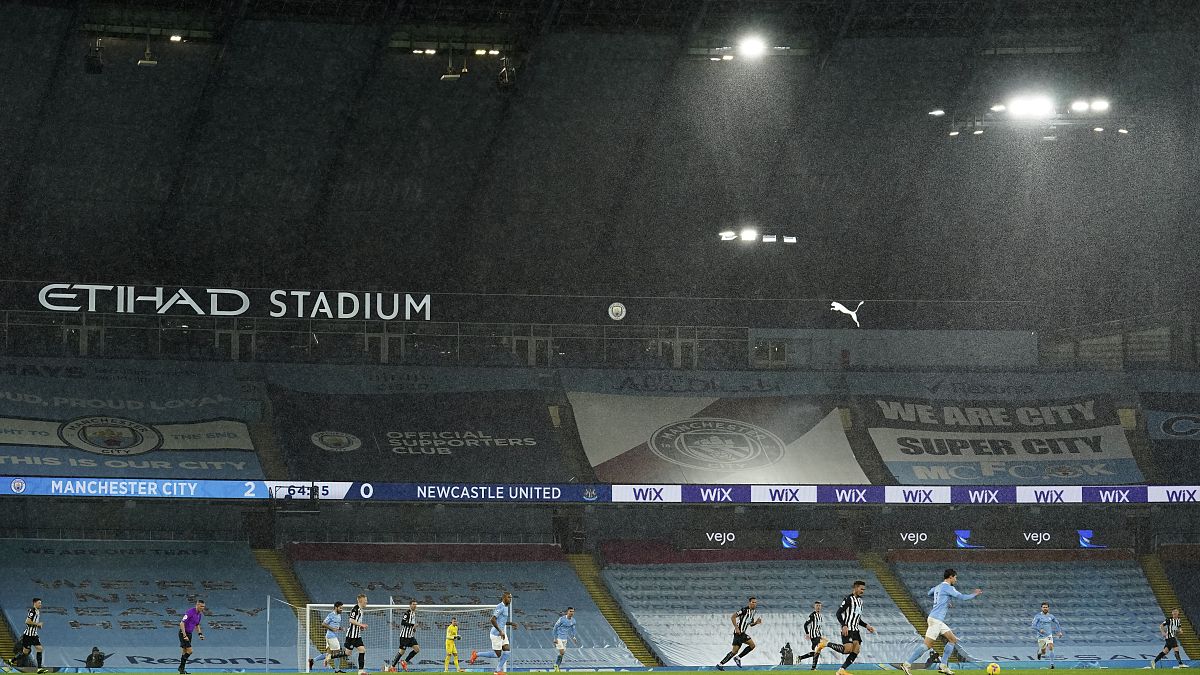 Players in the torrential rain during the English Premier League soccer match between Manchester City and Newcastle United at the Etihad stadium in Manchester.