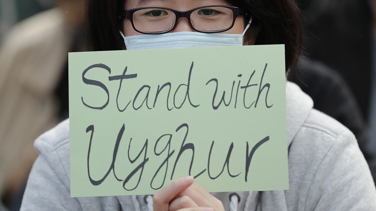 Hong Kong'da düzenlenen gösteriler sırasında Uygurlarla dayanışma içerisinde olduğunu belirten bir döviz taşıyan eylemci