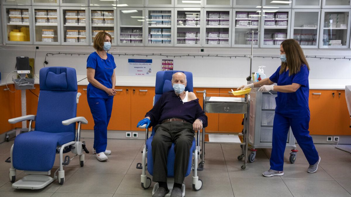 Michalis Giovanidis, a nursing home resident, waits to receive an injection with a dose of COVID-19 vaccine, in Athens