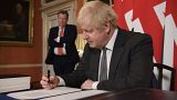 Boris Johnson signs the EU-UK Trade and Cooperation Agreement at 10 Downing Street, London Wednesday Dec. 30, 2020.