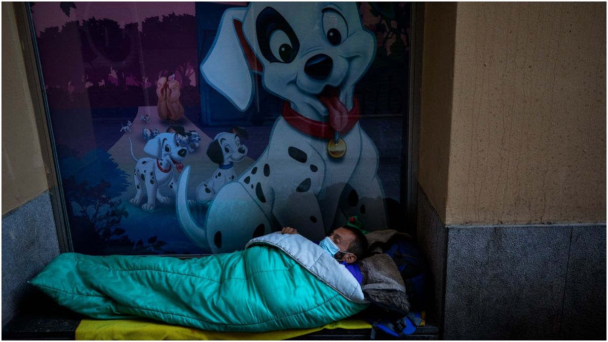 متشرد ينام في الشارع مرتديا قناعا في برشلونة- إسبانيا