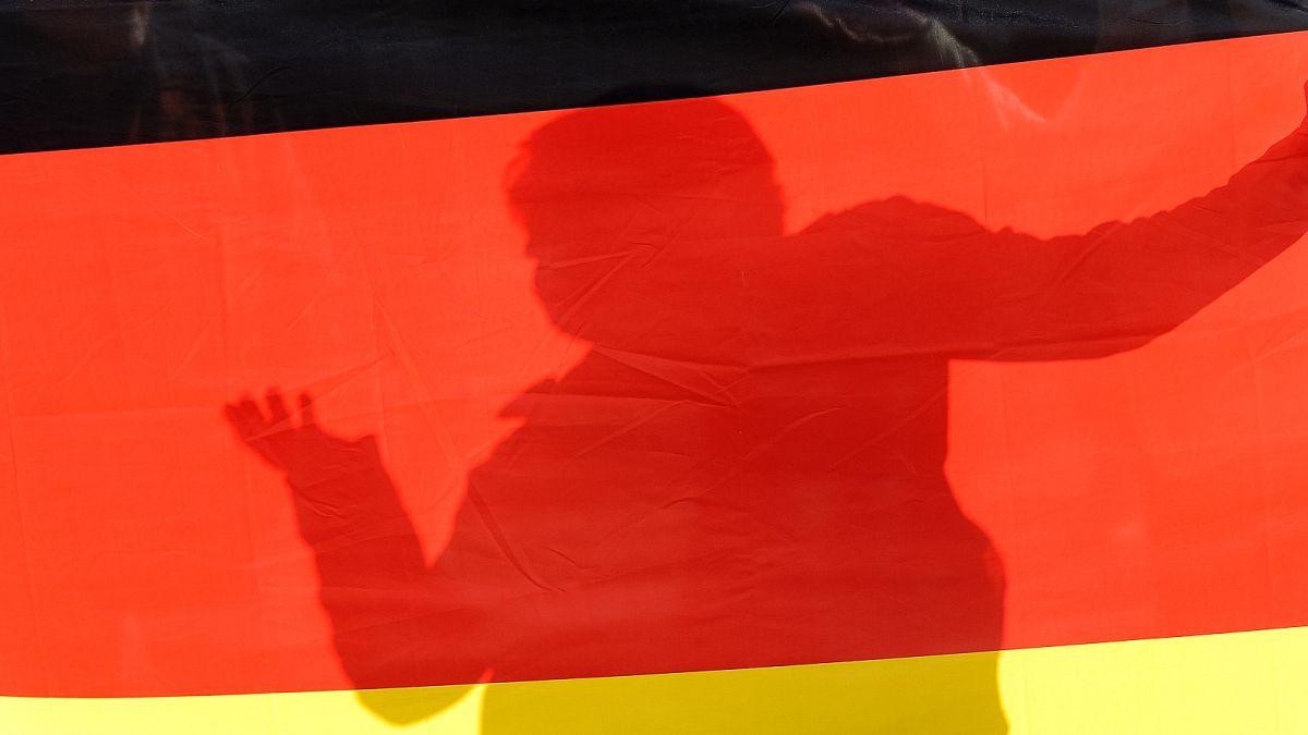 Egy szélsőjobbos nagygyűlés részvevője a német zászló árnyékában