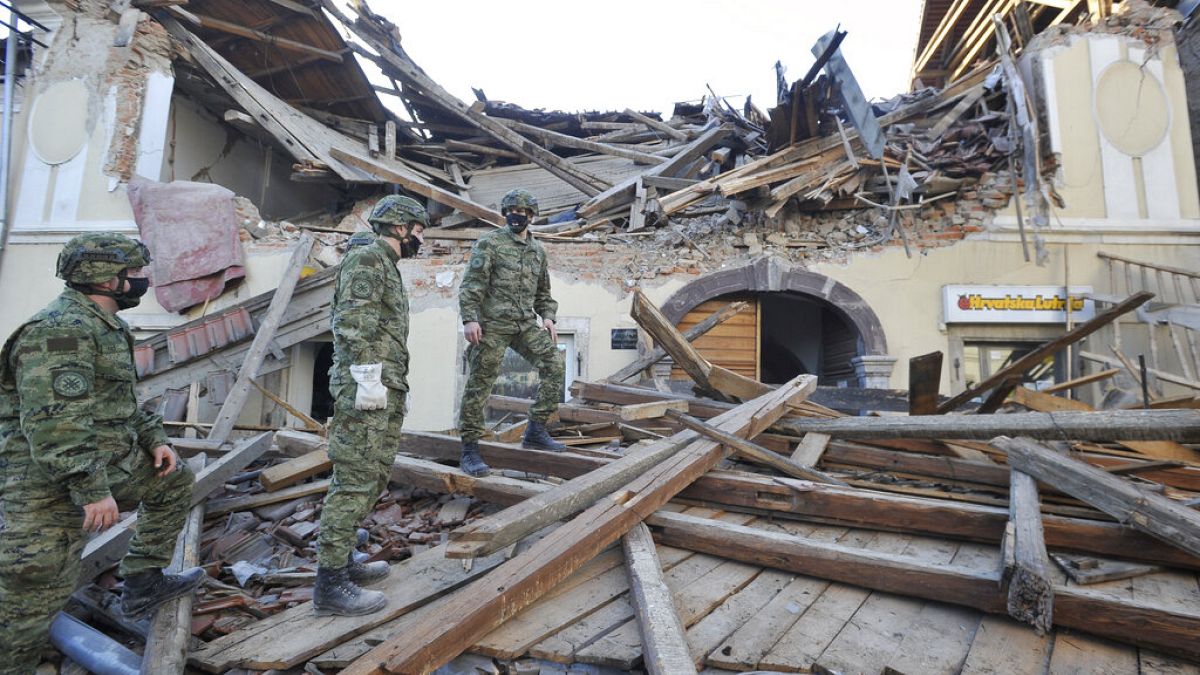 Soldiers inspect the remains of a building damaged in an earthquake, in Petrinja, Croatia, Tuesday, Dec. 29, 2020