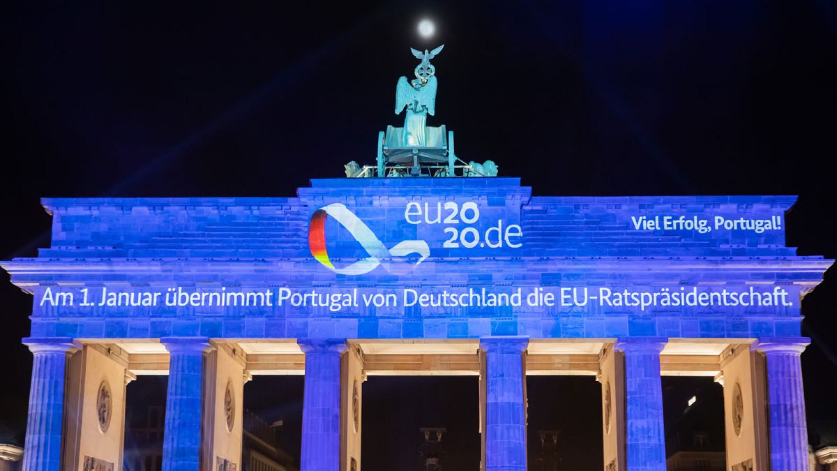 La porte de Brandebourg illuminée d'une projection marquant la fin de la présidence allemande de l'UE et le passage de témoin au Portugal, le 31 décembre 2020 à Berlin