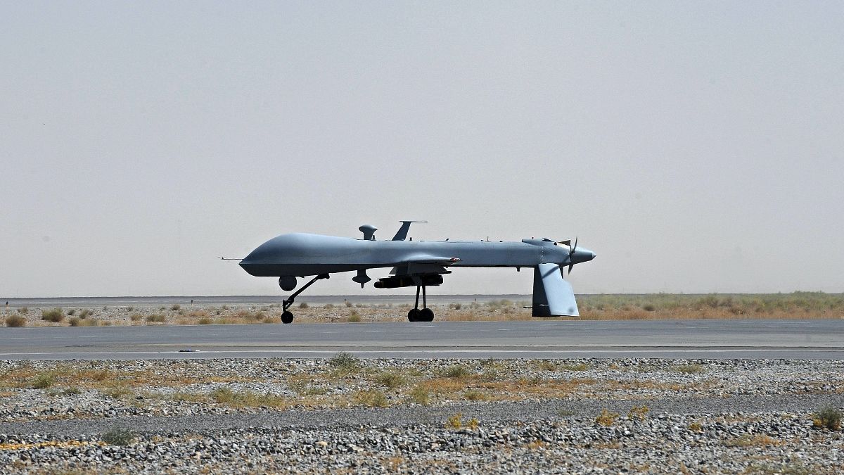 A US Predator unmanned drone armed with a missile stands on the tarmac of Kandahar military airport