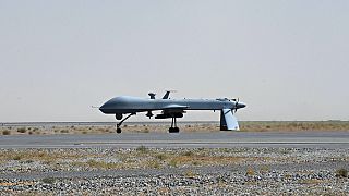 A US Predator unmanned drone armed with a missile stands on the tarmac of Kandahar military airport