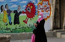 Nő sétál el az egyik graffiti előtt 