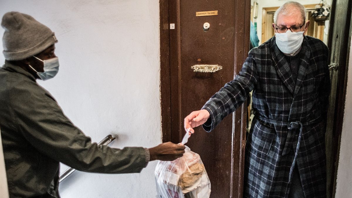 Lannseny delivers food to Piero, 74, in Livorno, Italy.