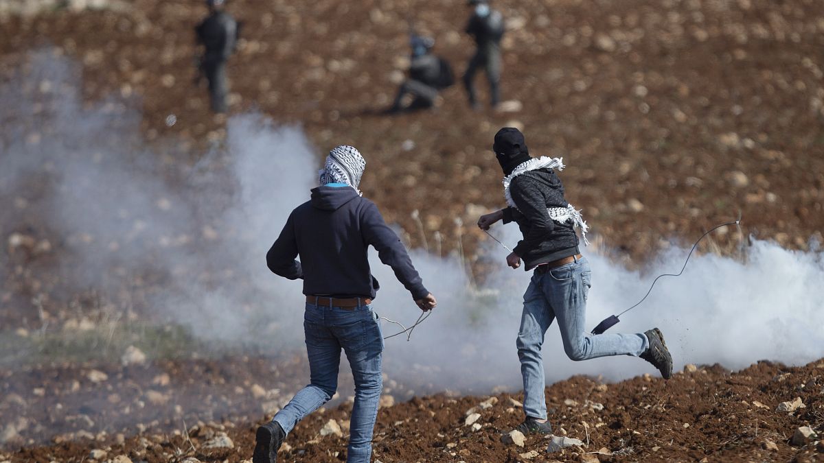 متظاهرون فلسطينيون يستخدمون المقلاع لرشق الحجارة باتجاه القوات الإسرائيلية خلال احتجاج ضد المستوطنات الإسرائيلية 
