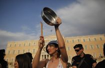 Yunanistan parlamentosu önünde tencere ve tavalara vurarak ses çıkarıp eylem yapan bir grup vatandaş.