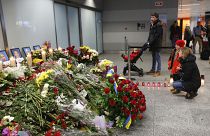 Flowers and candles are placed in front of portraits of the flight crew members of a Ukrainian jet that crashed near Tehran, at the Borispil airport, Ukraine, Jan. 11, 2020.