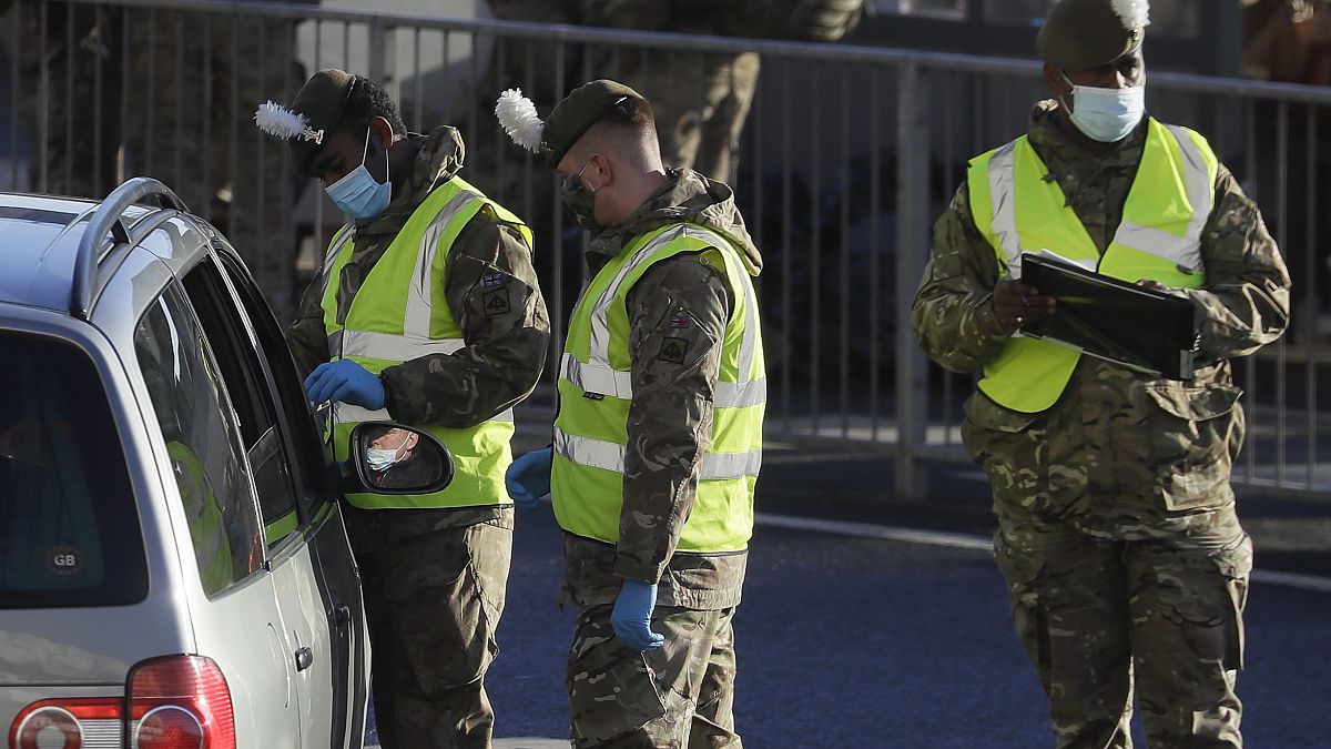 Soldiers carry out a COVID test on a driver at the entrance to The Port of Dover in Kent, England, Friday, Dec. 25, 2020.