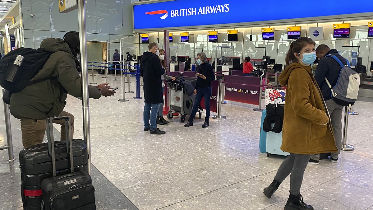 Viajeros británicos que regresan a sus casas en España esperan para hablar con el personal de la aerolínea después de que se les negara la entrada a los aviones.