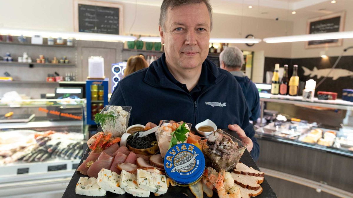 يقدم فالتر غرول  ، مزارع الأسماك وصاحب متجر لبيع الأطعمة الشهية، منتجاته بما في ذلك الكافيار الأبيض في بلدة غروديغ بالقرب من سالزبورغ، النمسا، 15 ديسمبر 2020 