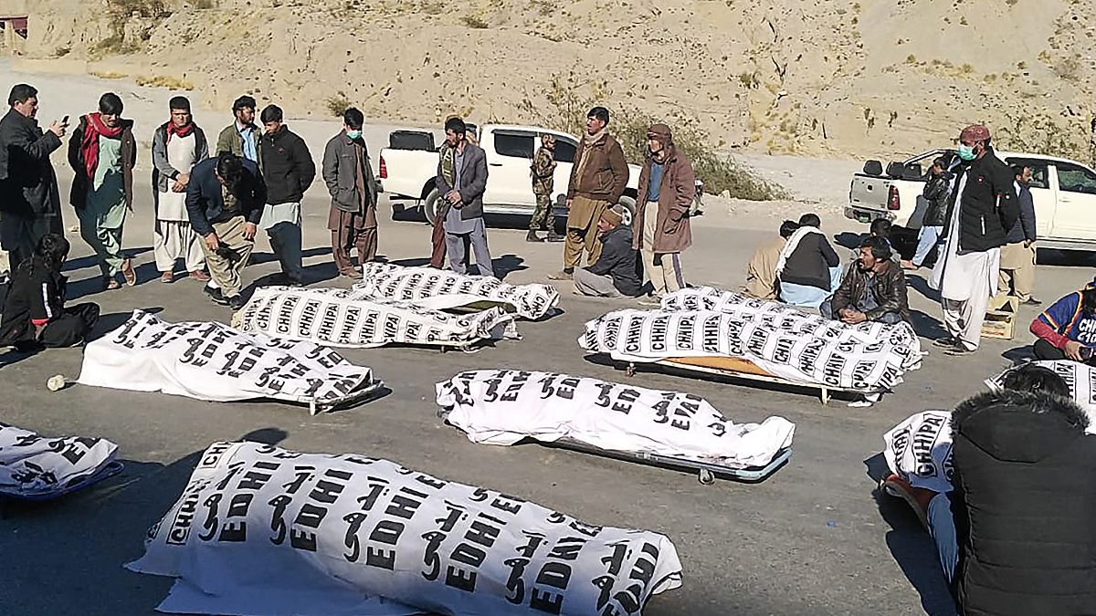 أفراد الطائفة الشيعية الهزارة يقفون حول الجثث بعد أن قتل مسلحون 11 عاملاً في منجم في منطقة ماخ الجبلية