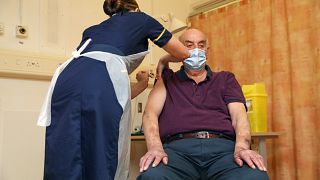 82-year-old Brian Pinker receives the Oxford University/AstraZeneca COVID-19 vaccine from nurse Sam Foster at the Churchill Hospital in Oxford, England, Monday, Jan. 4, 2021.