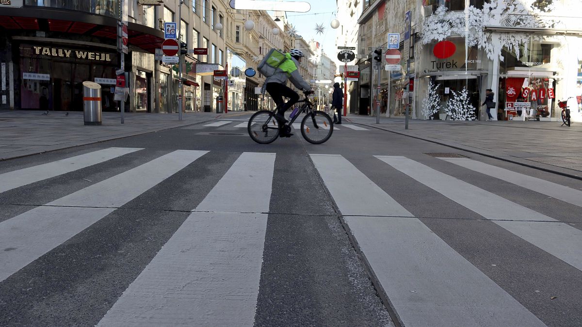 A cyclist drives on a shopping street in downtown Vienna, Austria