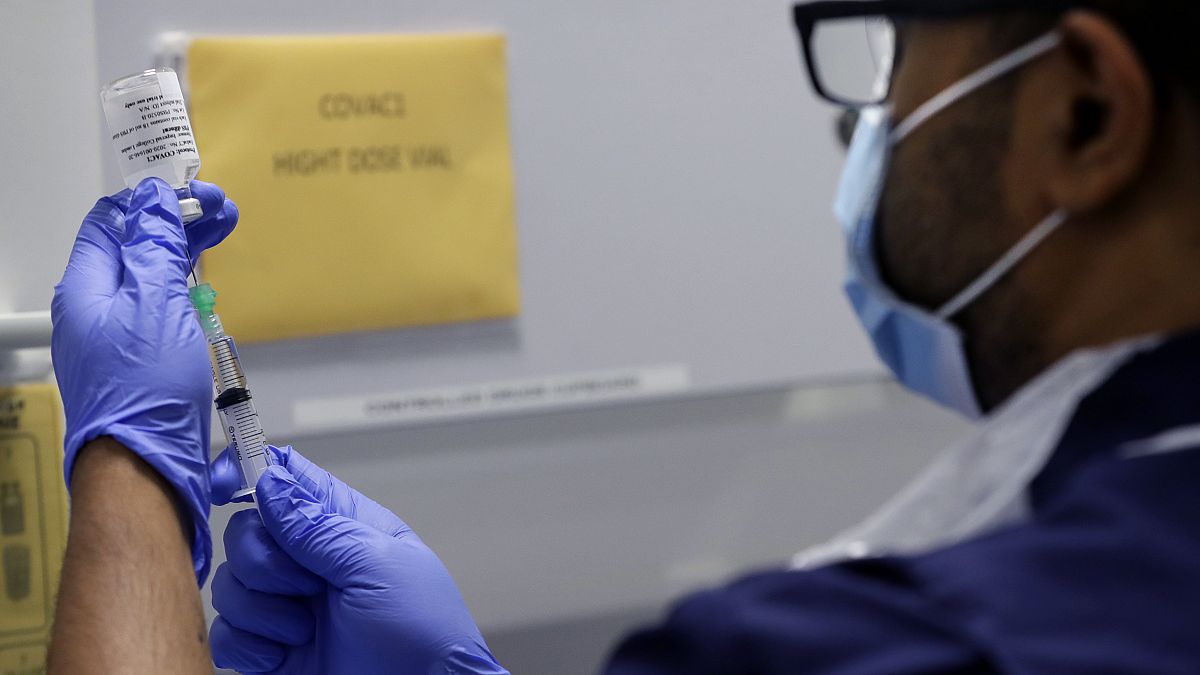 Senior Clinical Research Nurse Ajithkumar Sukumaran prepares the COVID 19 vaccine to administer to a volunteer, at a clinic in London, Wednesday, Aug. 5, 2020.