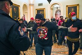 Partidarios de Trump se encaran contra la policía del Capitolio de EE.UU. en el pasillo fuera de la cámara del Senado en el Capitolio de Washington, el miércoles 6 de enero.