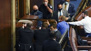 U.S. Capitol Police with guns drawn stand near a barricaded door as protesters try to break into the House Chamber at the U.S. Capitol on Wednesday, Jan. 6, 2021.