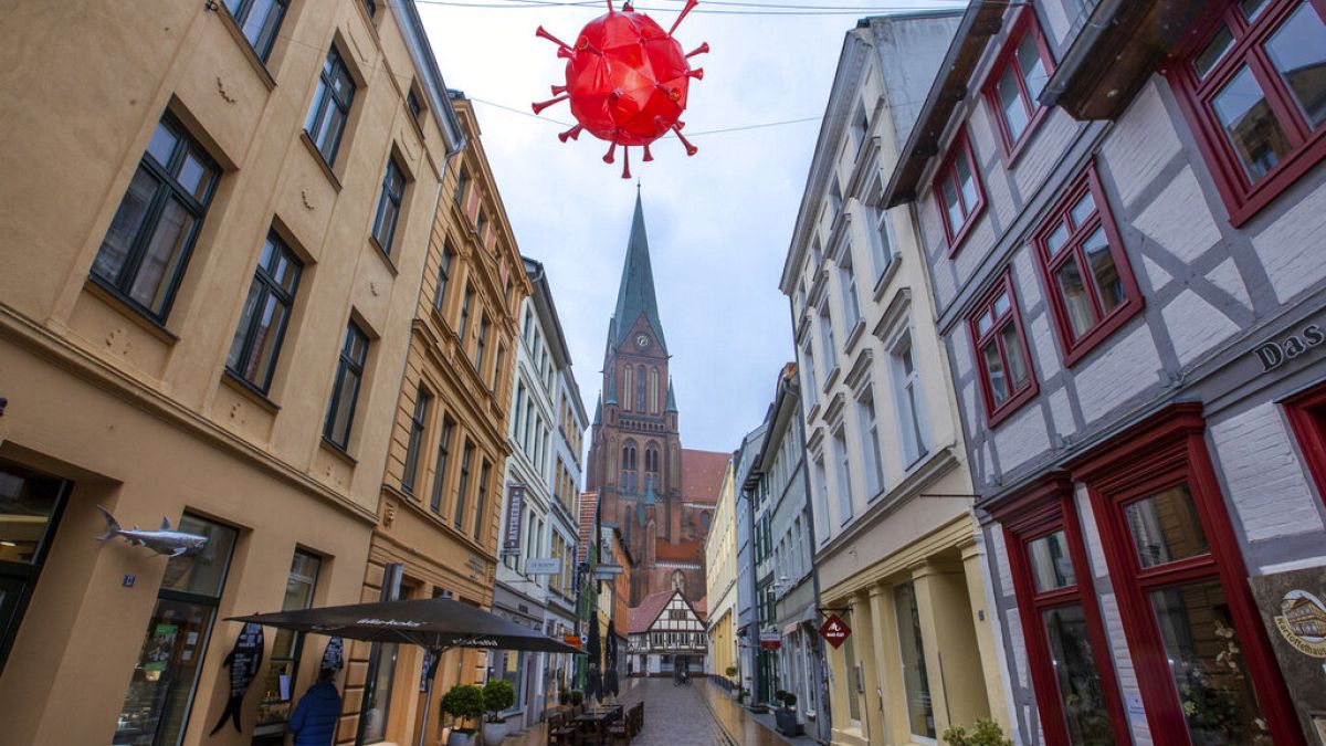 Coronavirus-Lampion hängt über einer Einkaufsstraße vor dem Turm des Schweriner Doms, 5.1.2021
