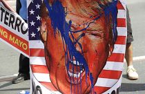 An image of U.S. President Donald Trump is splashed with paint by protesters as they hold a rally opposing the recent attack of the U.S. against Iran, where it killed Soleiman