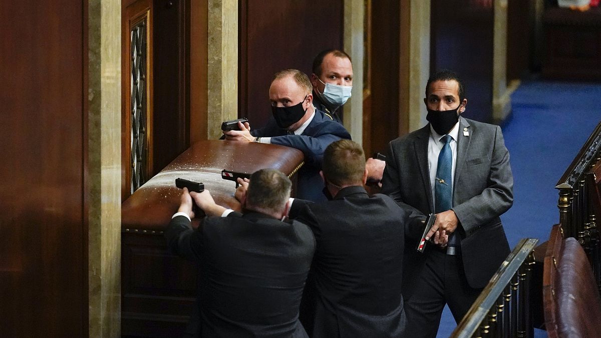 Policías del Capitolio defienden con sus armas en la mano una de las entradas de la Cámara de Representantes