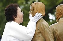II. Dünya Savaşı sırasında "konfor kadın" olarak kullanılan bir mağdur anma töreninde anıta dokunurken