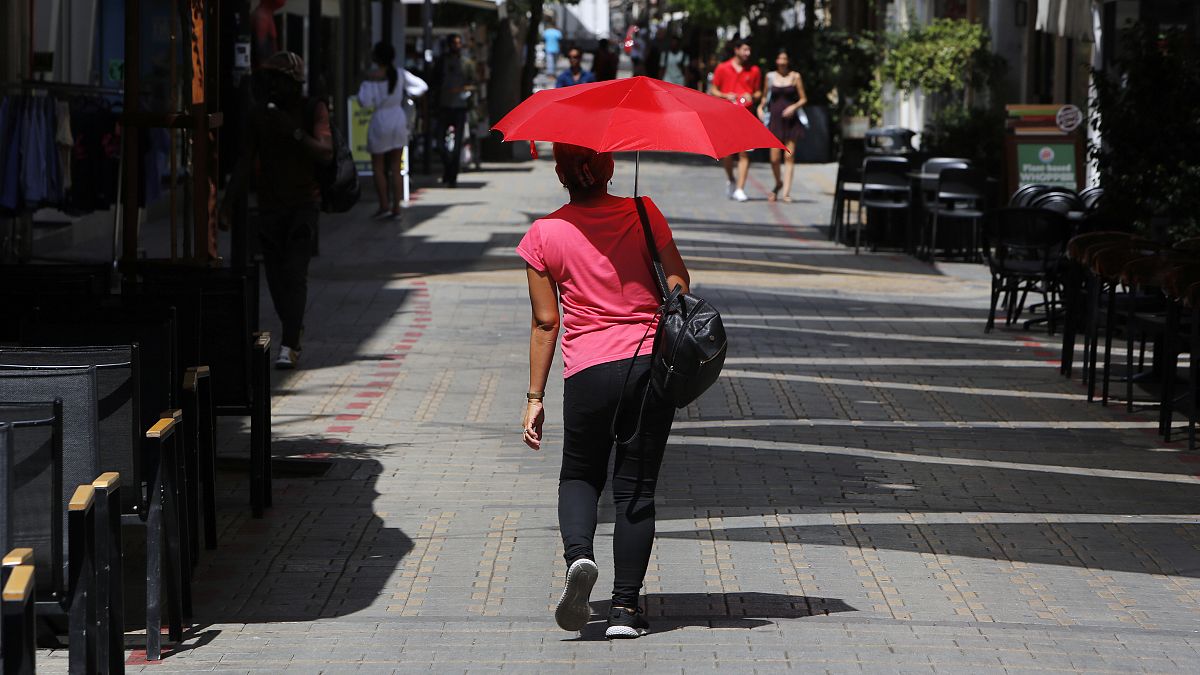  A woman shields herself from the sun with an umbrella amid a heatwave in Nicosia, Cyprus, Friday, Sept. 4, 2020.