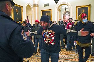 Trump supporters gesture to U.S. Capitol Police in the hallway outside of the Senate chamber at the Capitol in Washington, Wednesday, Jan. 6, 2021.