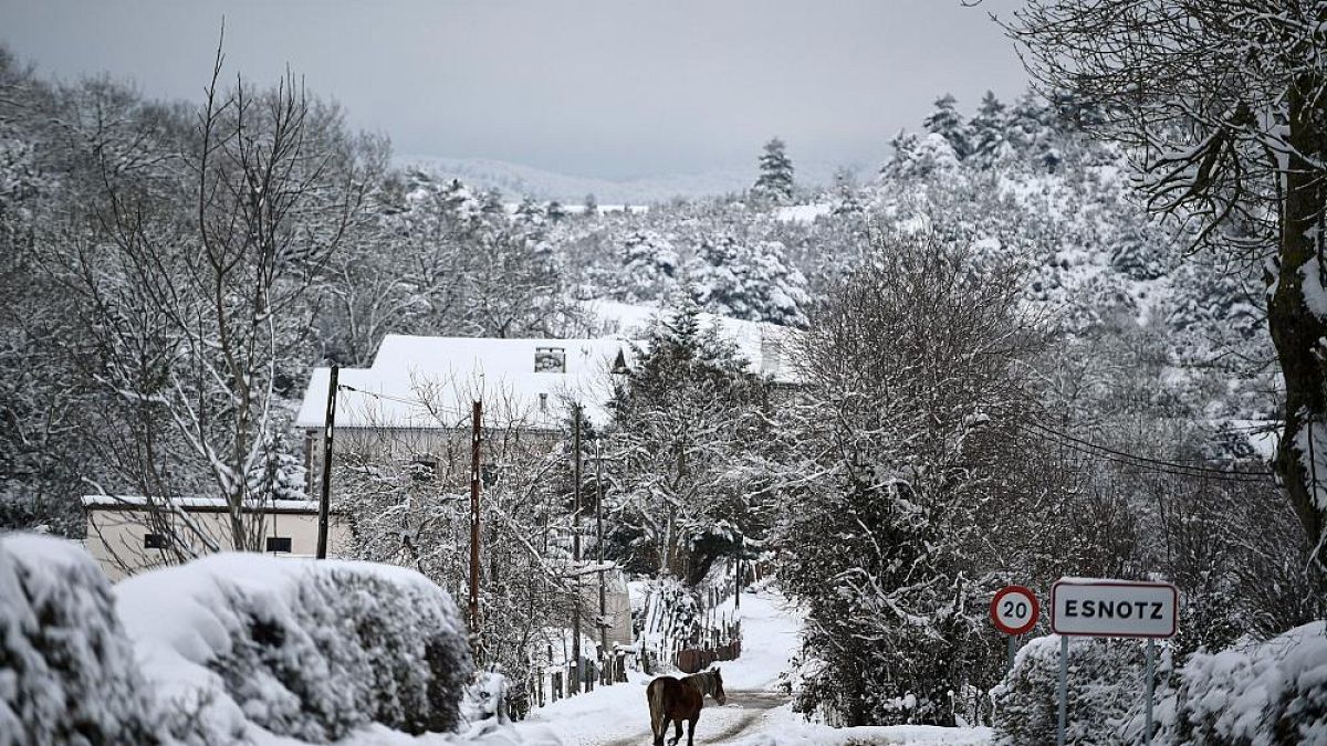 Ein Pferd trabt durch das verschneite baskische Dorf Esnotz, Navarra, in den Pyrenäen