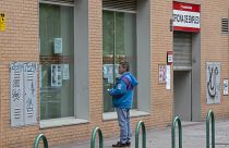En esta foto de archivo del martes 28 de abril de 2020, un hombre mira los avisos en la ventana de una oficina de desempleo en Madrid, España.