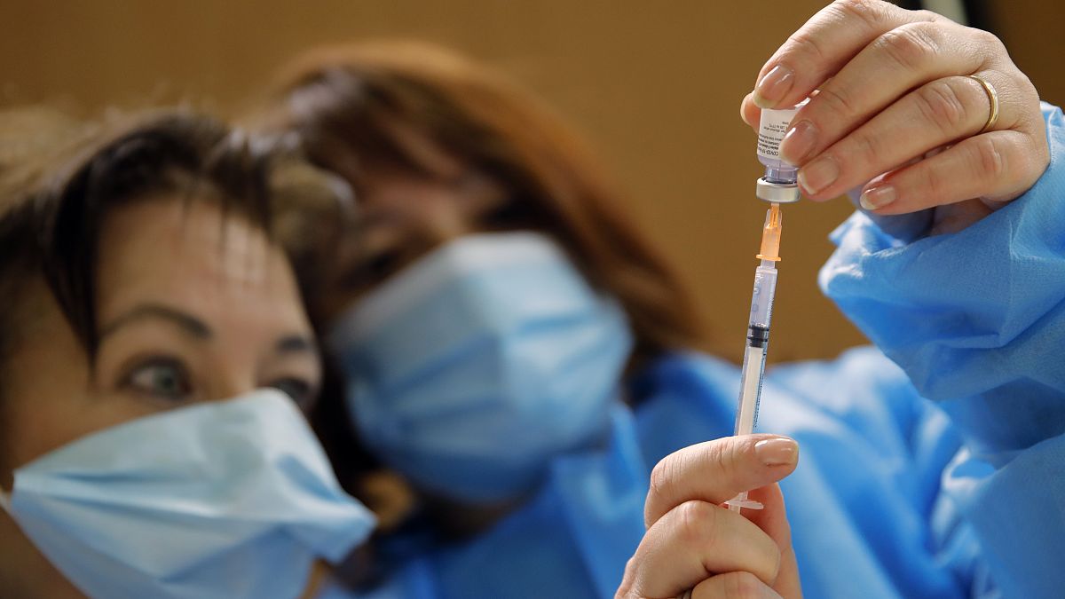 Nurses prepare a Pfizer-BioNTech COVID-19 vaccine to be administered to a health care worker at a coronavirus vaccine center in Poissy, France, Friday, Jan.8, 2021.