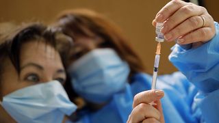 Nurses prepare a Pfizer-BioNTech COVID-19 vaccine to be administered to a health care worker at a coronavirus vaccine center in Poissy, France, Friday, Jan.8, 2021.