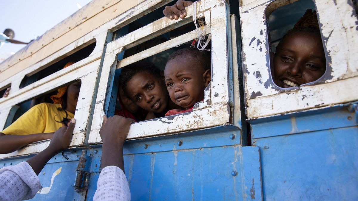 Refugees who fled the conflict in Ethiopia's Tigray region ride a bus going to the Village 8 temporary shelter, near the Sudan-Ethiopia border, in Hamdayet, eastern Sudan.