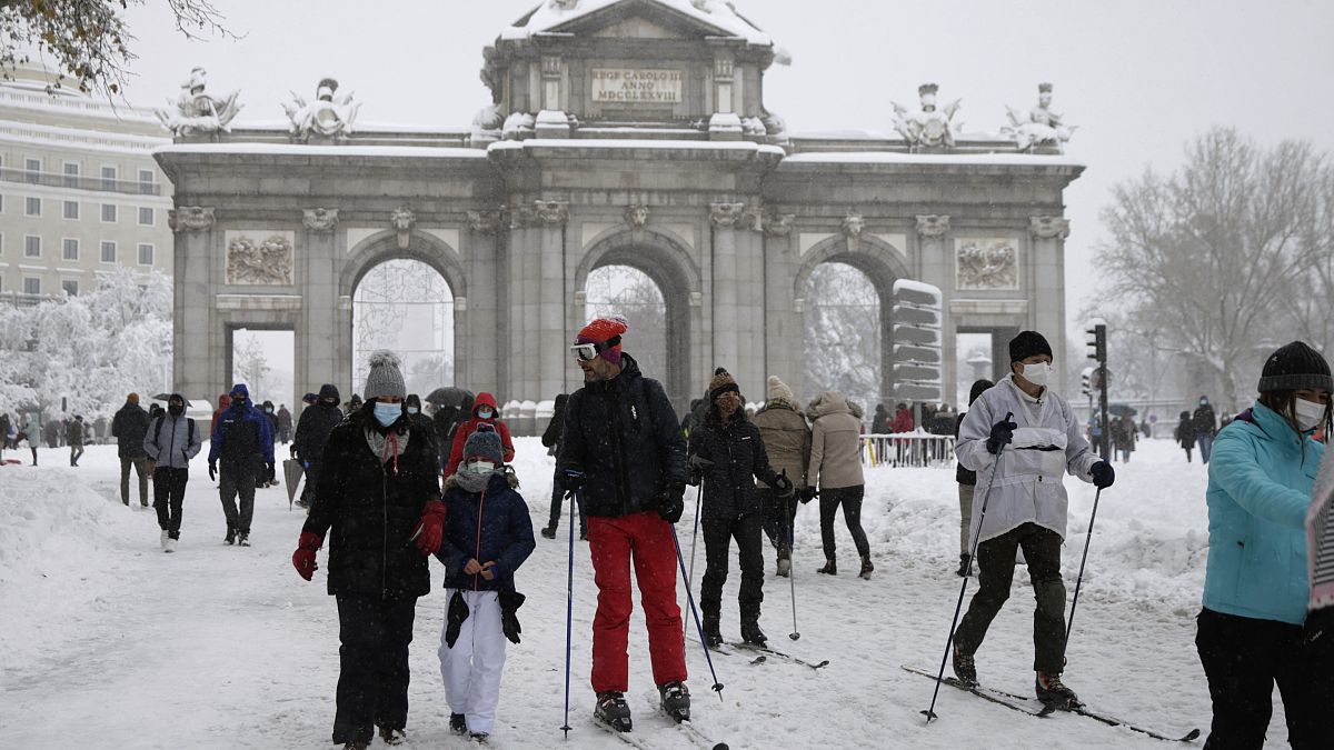 La gente delante de "La Puerta de Alcalá" durante la fuerte nevada en el centro de Madrid, España, el 9 de enero de 2021.
