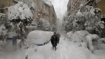 People walk during a heavy snowfall in Madrid, Spain, Saturday, Jan. 9, 2021