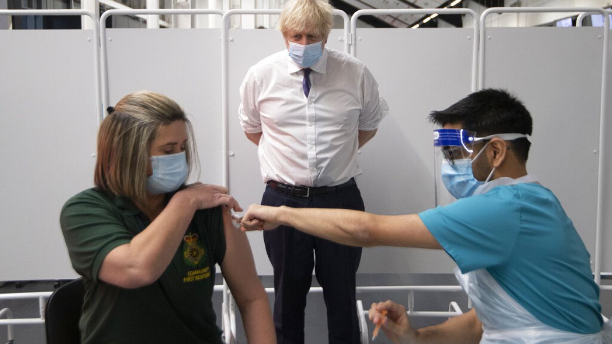 Britain's Prime Minister Boris Johnson watches first responder Caroline Cook receiving an injection of a Covid-19 vaccine at Ashton Gate Stadium in Bristol, England
