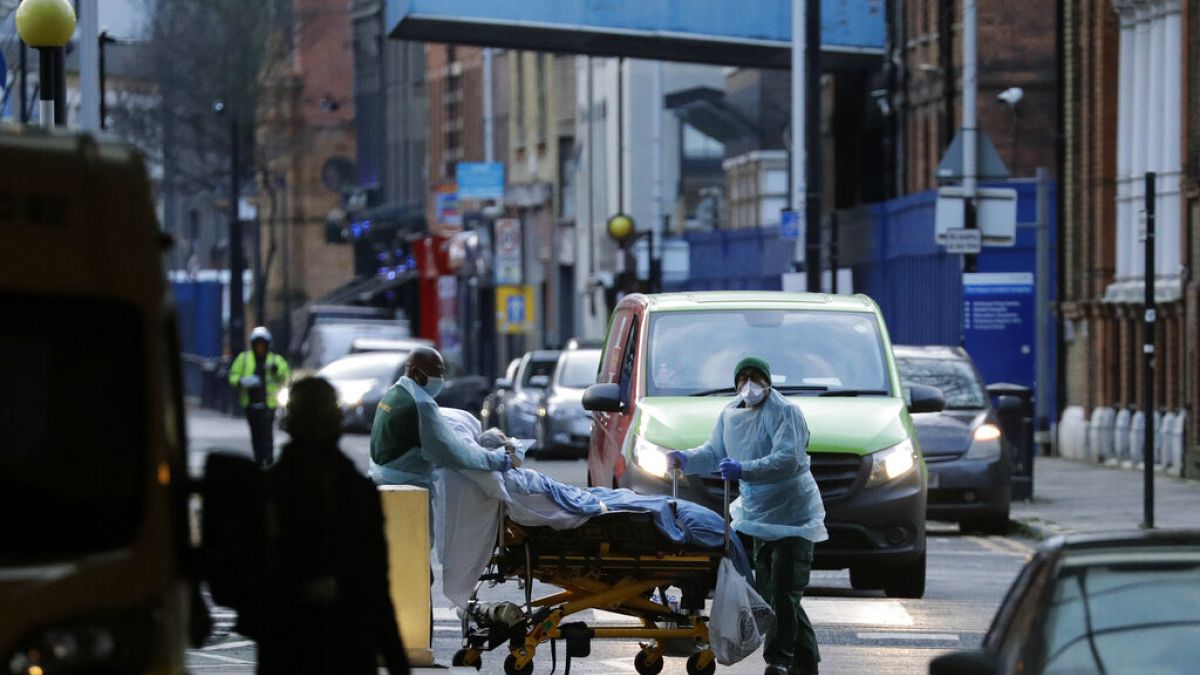 A patient is pushed on a trolley outside the Royal London Hospital in east London, Tuesday, Jan. 12, 2021.
