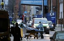 A patient is pushed on a trolley outside the Royal London Hospital in east London, Tuesday, Jan. 12, 2021.