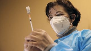 A nurse, Ines, prepares a Pfizer-BioNTech COVID-19 vaccine to be administered to a health care worker at a coronavirus vaccine center in Poissy, France, Friday, Jan.8, 2021.