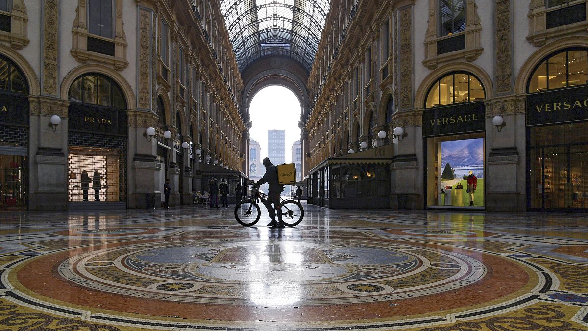 Доставщик еды в пустом торговом центре в Милане 6 ноября 2020