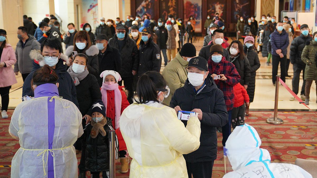 Koronavírus-vizsgálathoz állnak sorban emberek Sicsiacsuangban