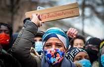 IB's mother takes part in a demonstration on January 13, 2021, outside the police station in Brussels where her son was held