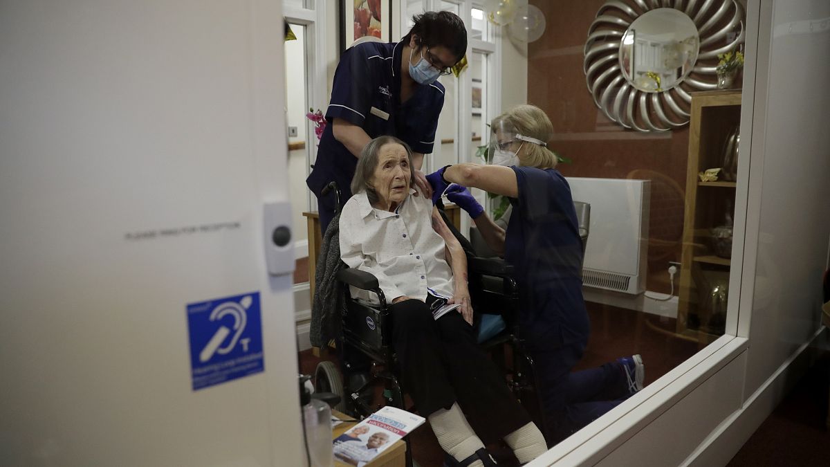 A care home resident receives her first dose of the Oxford/AstraZeneca COVID-19 vaccine