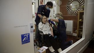 A care home resident receives her first dose of the Oxford/AstraZeneca COVID-19 vaccine