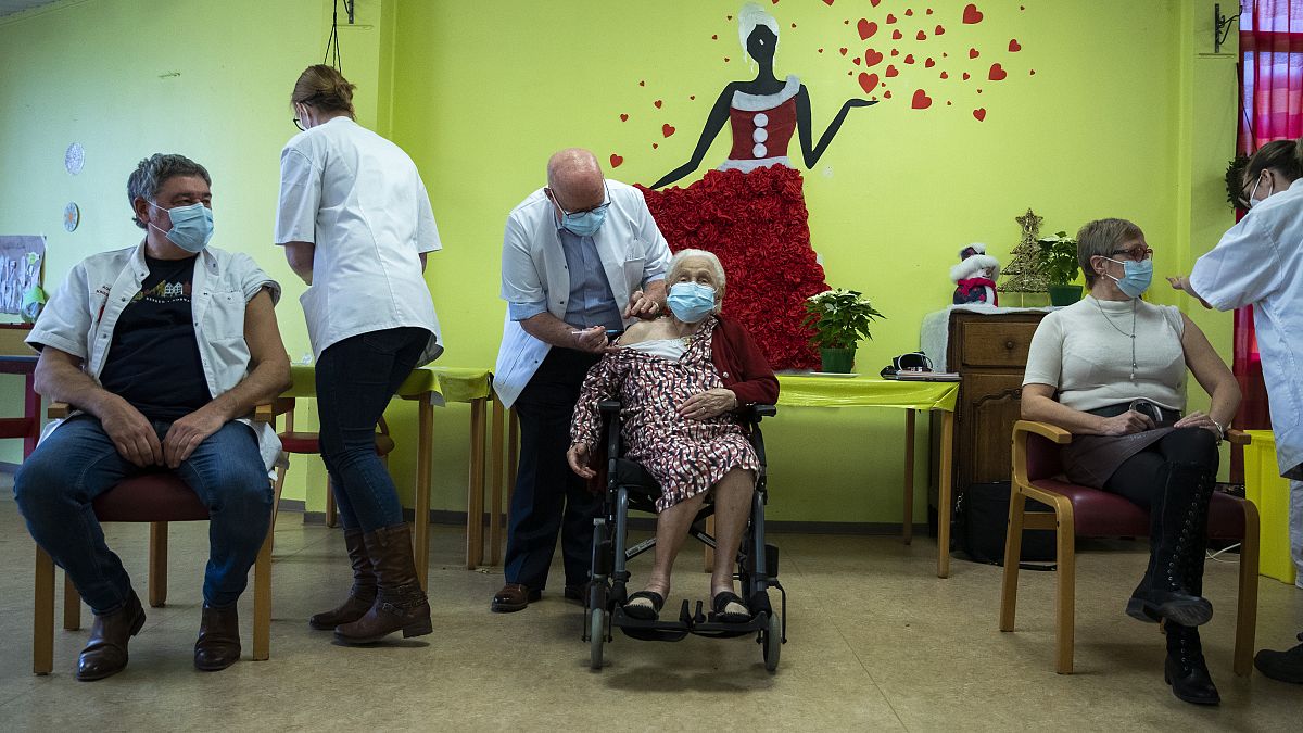 ممرضة تقدم لقاح كوفيد في دار رعاية المسنين في مونس، بلجيكا. 