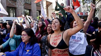 "En pleno siglo XXI por mi cuerpo aún deciden otros", se lee en el cuerpo de la manifestante de la protesta feminista en Santiago. (Foto de archivo).