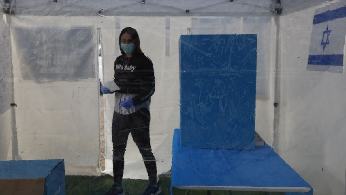 متطوعة داخل خيمة معقمة مخصصة للناخبين المصابين بالفيروس. 